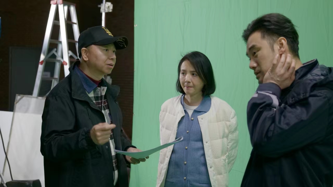 Three people in a green-screen production setting