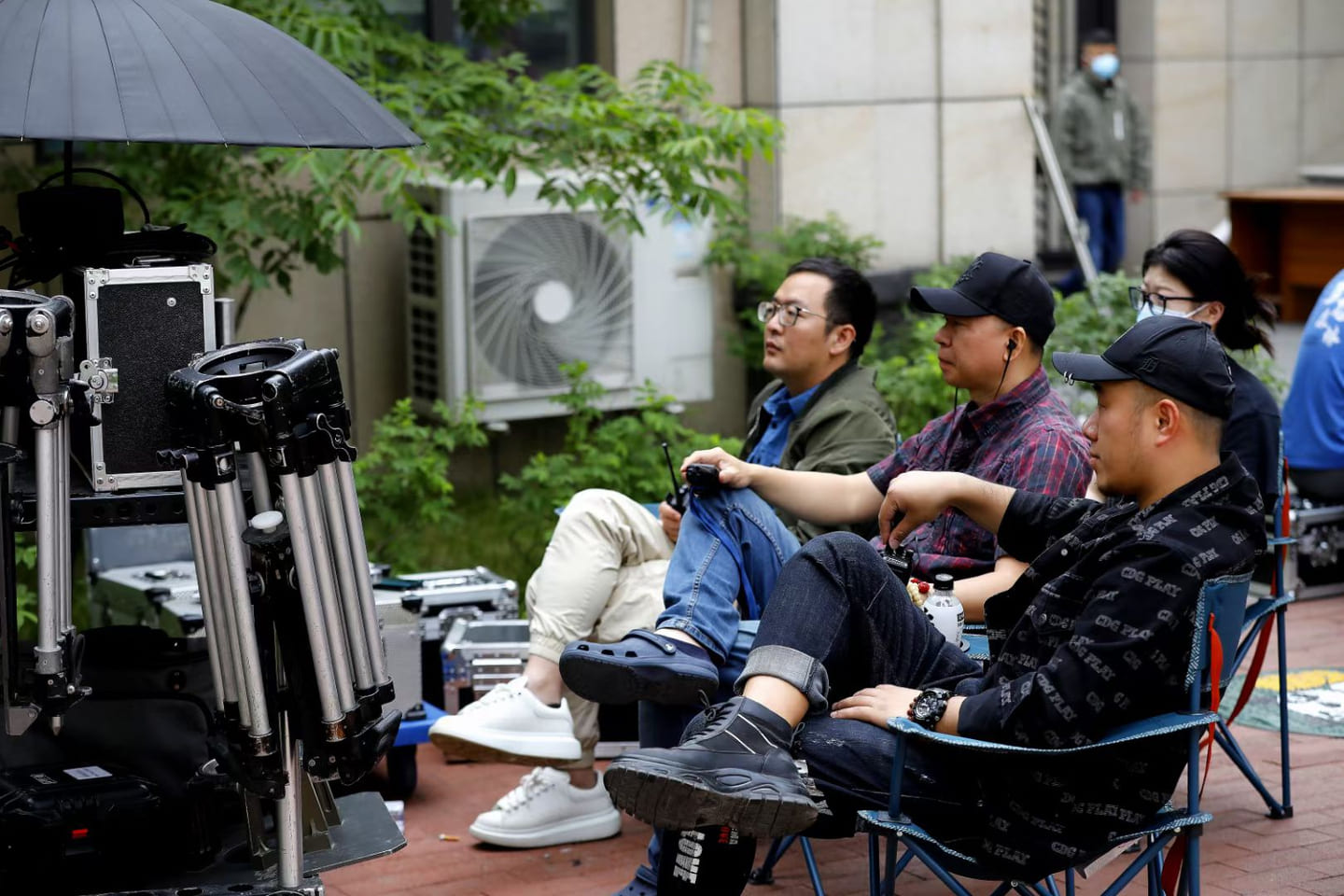 Behind the scenes on the set of Against the Wind, with a seated crew member beside professional camera equipment