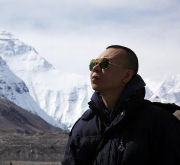 Zhaohui Hu during documentary field production near snow-covered mountains